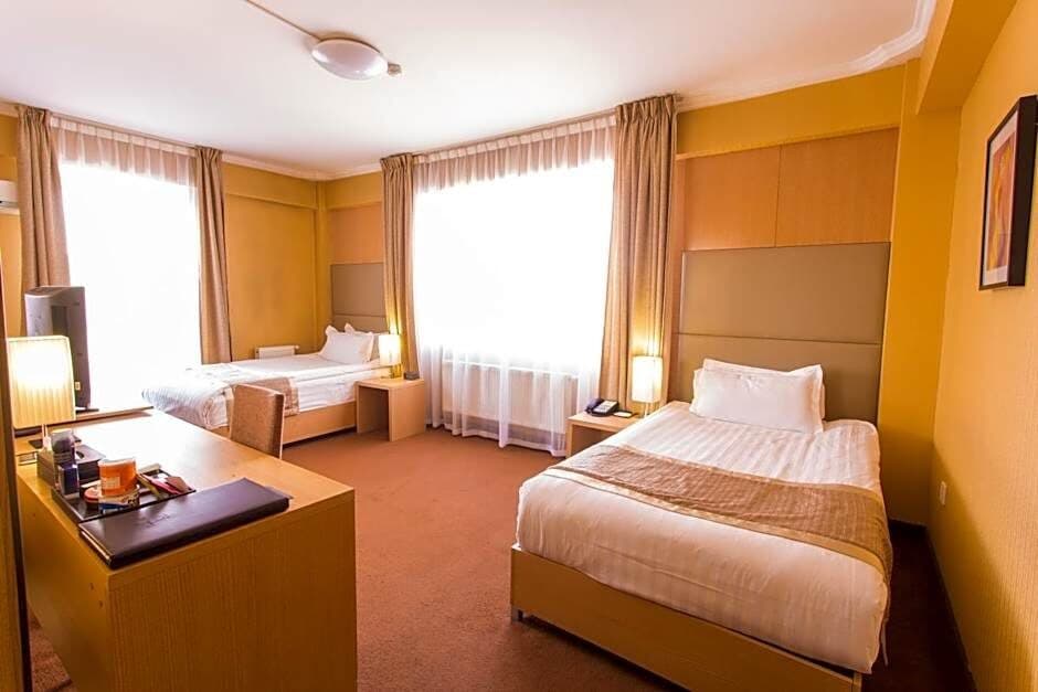 A twin hotel room with warm lighting